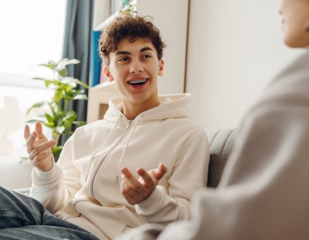 Jovem em sessão de terapia conversando com profissional.