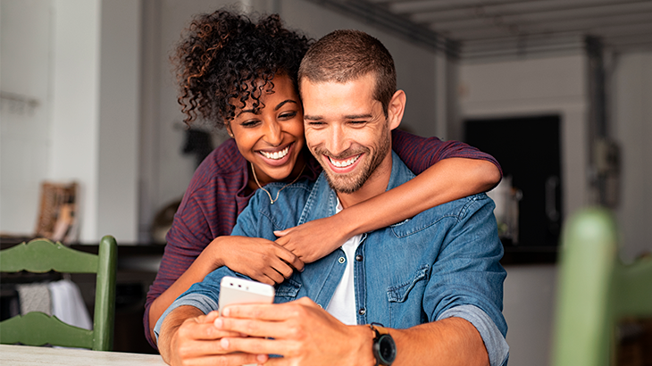 casal sorrindo para telefone