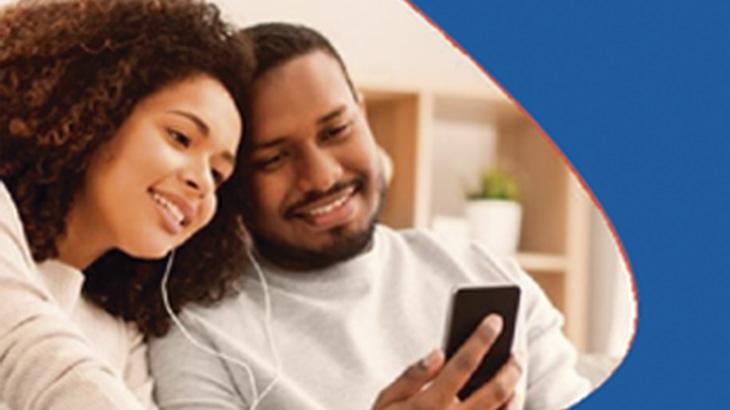 casal utilizando telefone e sorrindo