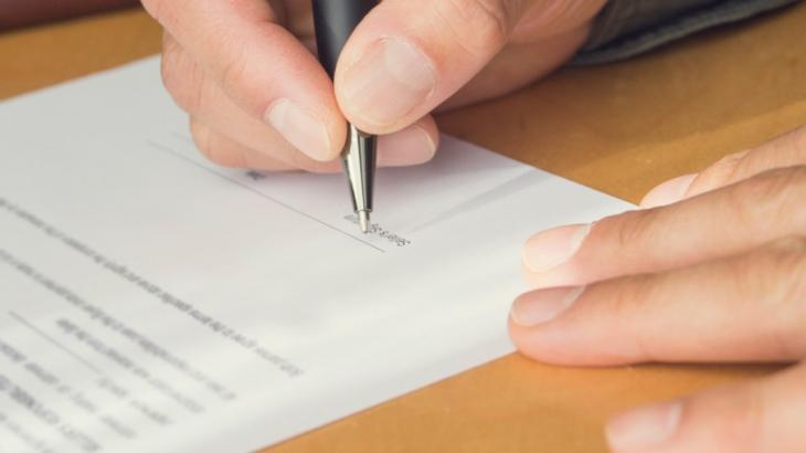 mão assinando um contrato