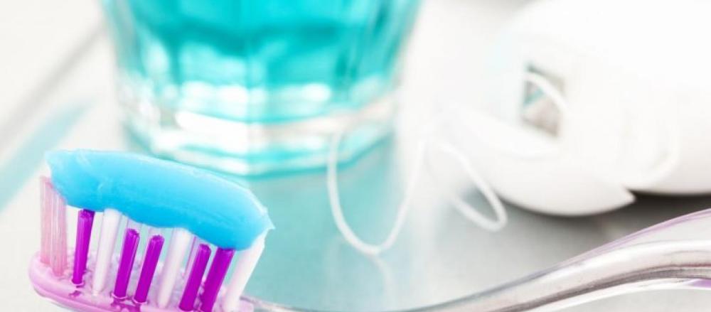 Close em uma escova de dentes e um copo de exaguante bucal
