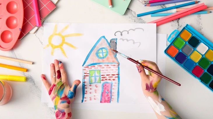 Mãos brincando com lápis de cor e aquarela