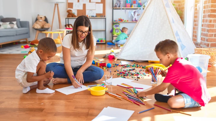 Crianças brincando no chão com adulto