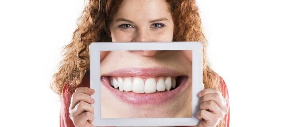Mulher segurando foto de um sorriso