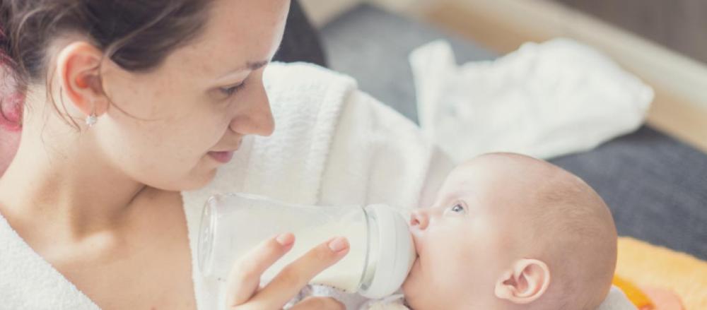 Mãe amamentando bebê com mamadeira