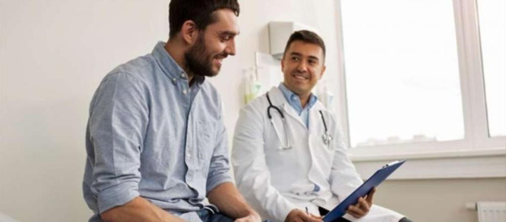 Homem sorrindo em uma consulta médica
