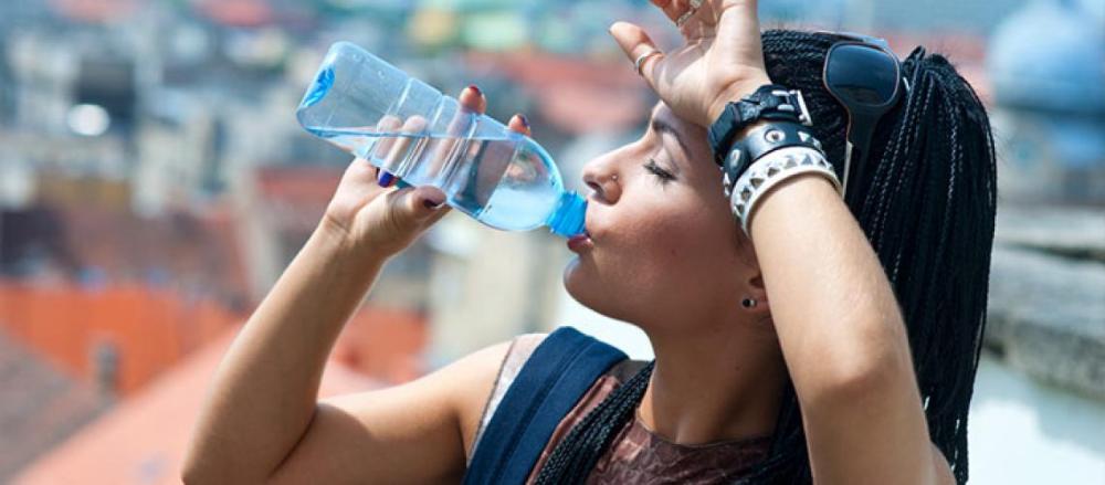 Mulher bebendo uma garrafa de água em um bloco de carnaval
