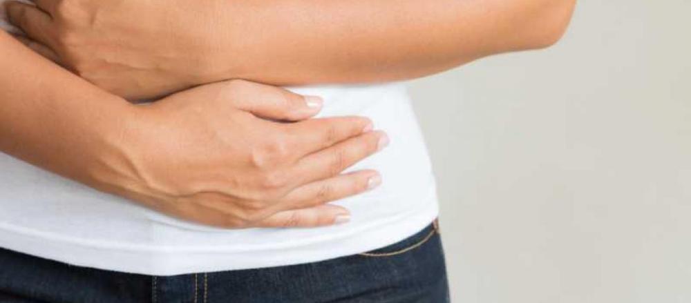 Pesssoa levando as mãos a barriga, indicando dores