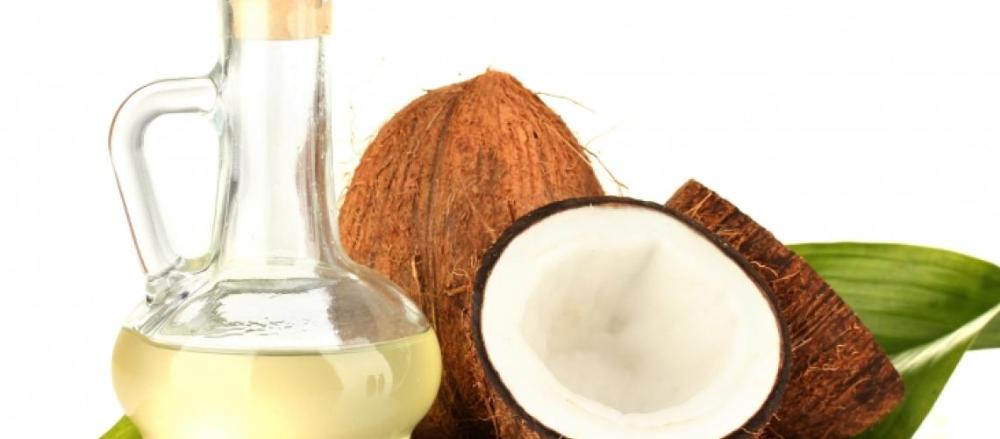 Vidro com oleo de coco e um coco natural aberto