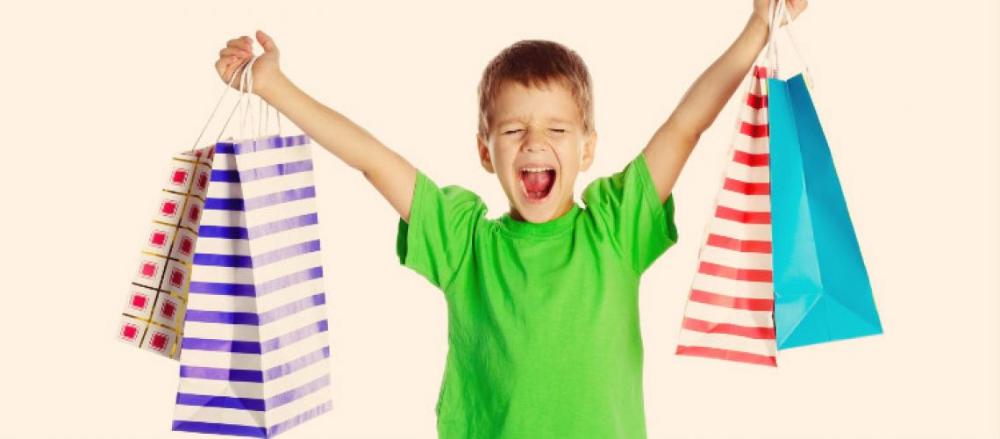 Criança feliz segurando sacolas de compras