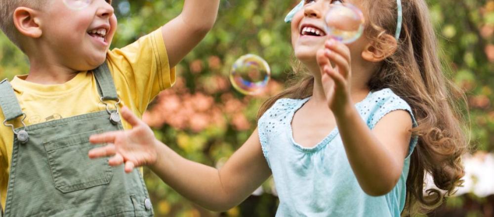 Crianças felizes brincando com bolhas de sabão