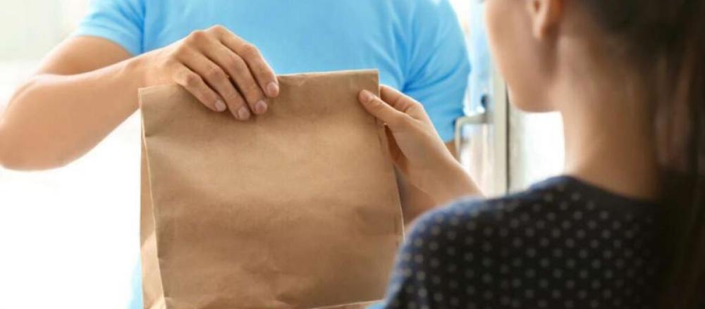 Uma pessoa recebendo uma entrega de delivery de comida