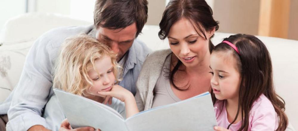 Familía reunida em um sofá lendo um livro