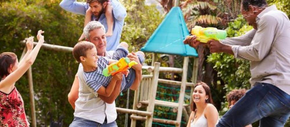 Família feliz brincando com armas de água