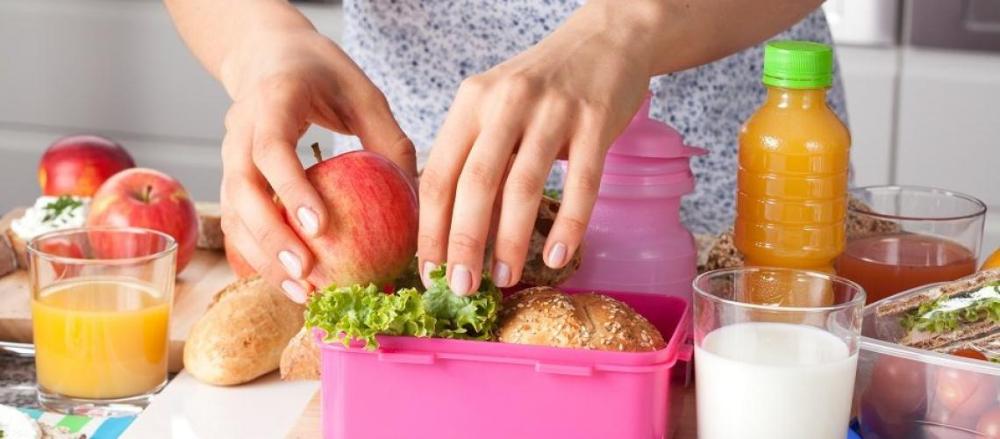 Pessoa preparando lanche saudável, com frutas e sucos