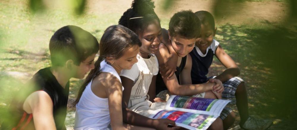 Grupo de crianças lendo juntas o mesmo livro