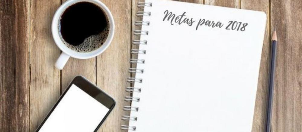 Imagem de uma mesa com um celular, uma xícara de café e um caderno com os dizeres
