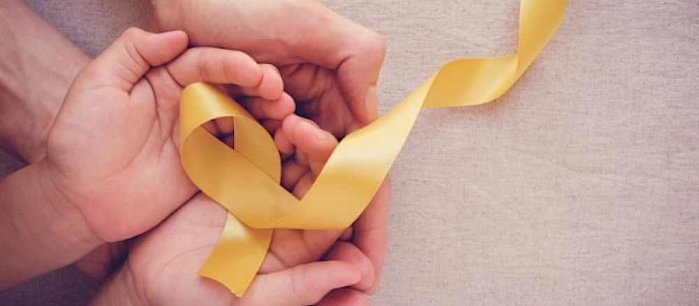 Imagem de duas pessoas com as mãos sobrepostas, enquanto uma segura uma fita amarela, em alusão ao setembro amarelo