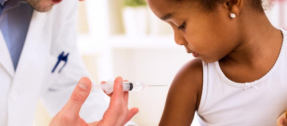 Médico aplicando vacina em criança