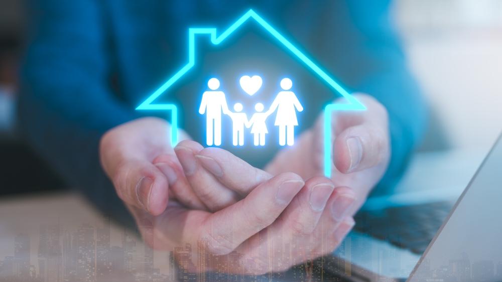 Mãos segurando ícone digital de casa com família, simbolizando plano de saúde PME, coparticipação e estratégias para economizar mantendo cobertura completa.