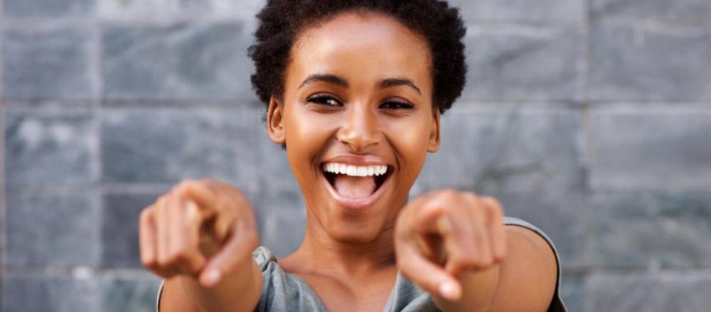 Mulher sorrindo apontando para a frente