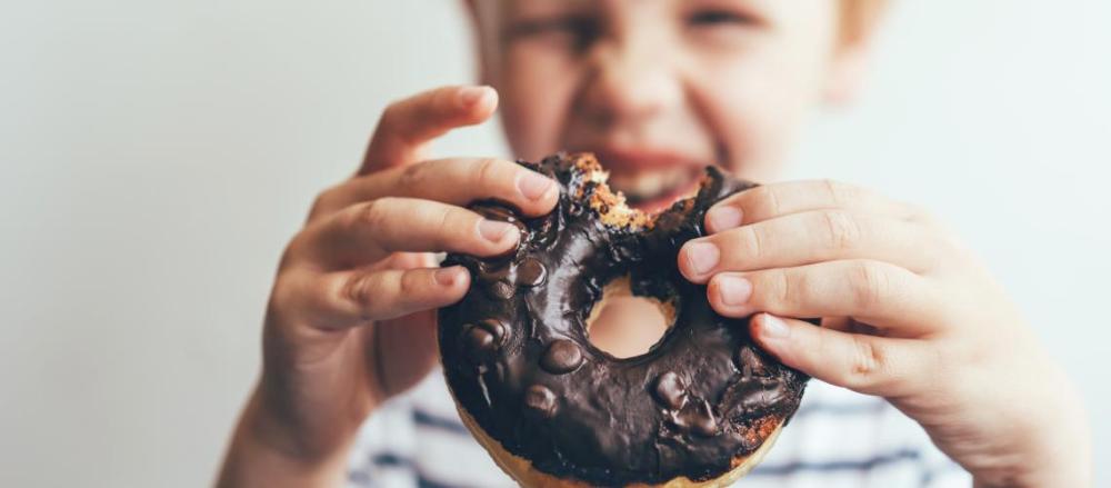 Criança comendo um donuts