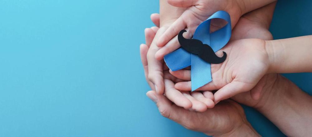 Dois apres de mão sobrepostas com uma faixa azul acima e um bigode, em alusão ao novembro azul