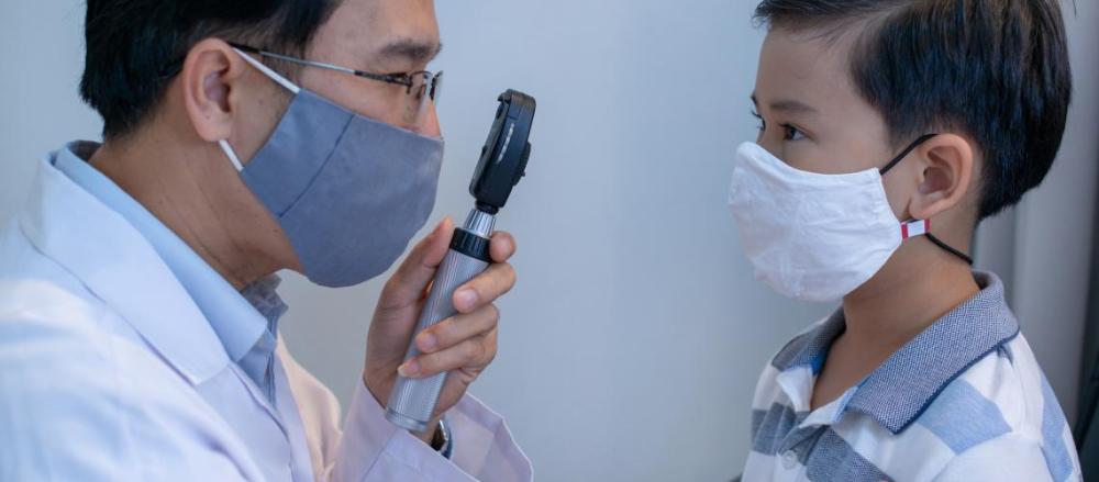 Médico examinando os olhos de um menino