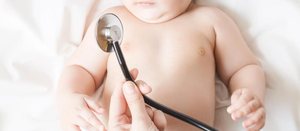 Bebê deitado, com um estetoscópio em destaque