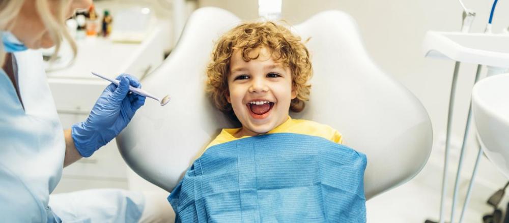 Criança sorrindo em um atendimento com dentista