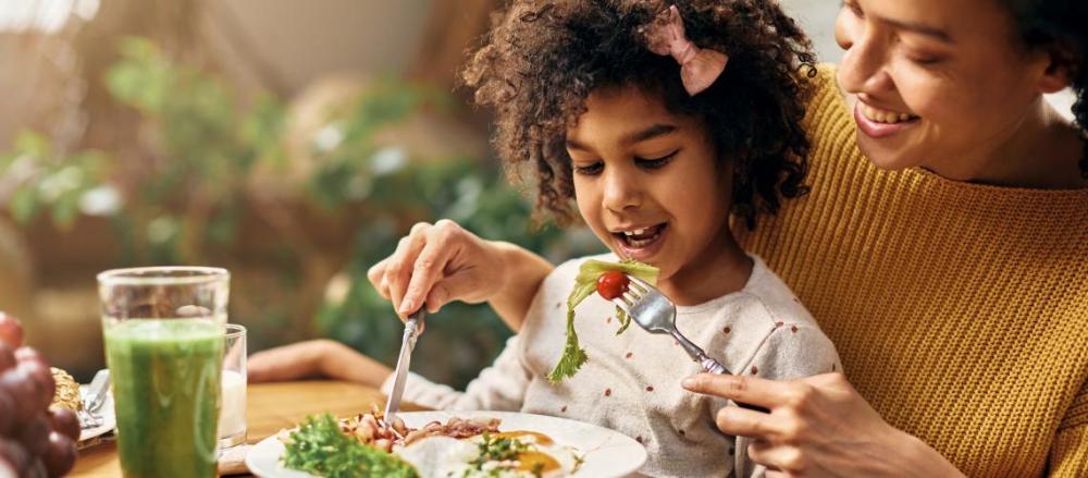 Mãe e filha comendo uma alimentação verde e saudável