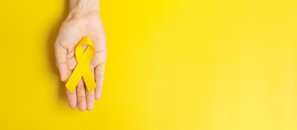 Mão segurando fita do setembro amarelo