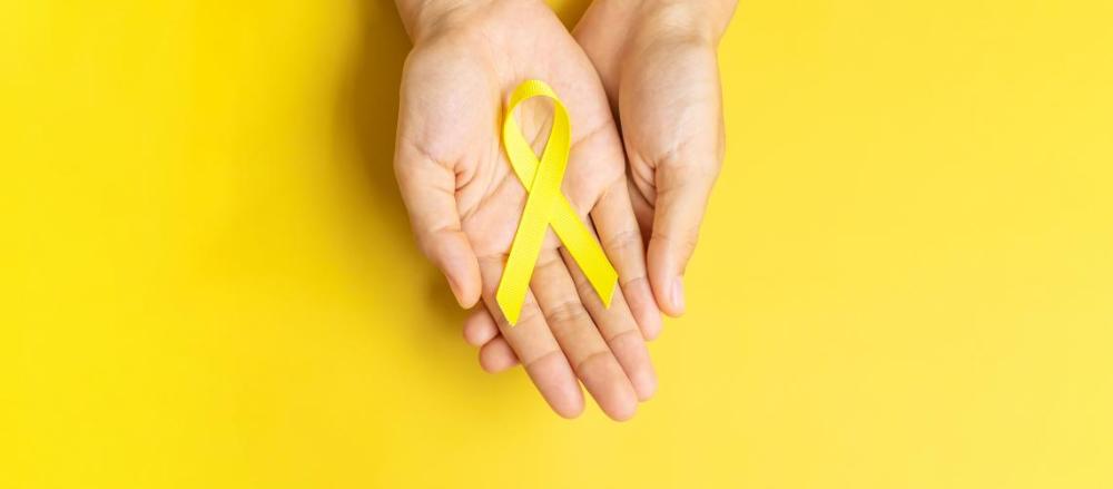 Imagem de uma mão segurando umma fita amarela com o fundo amarelo, em alusão so setembro amarelo