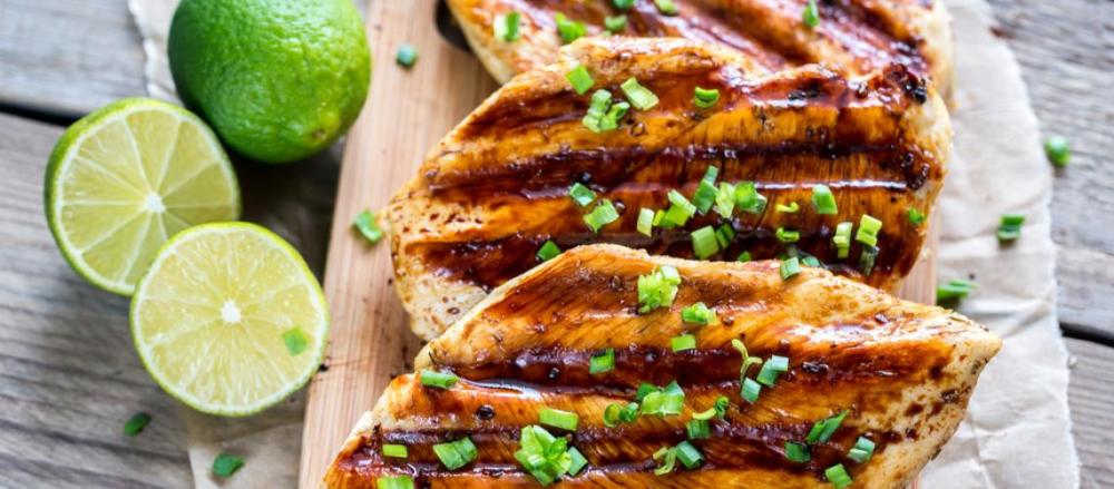 Tábua com filés de frango e limões cortados