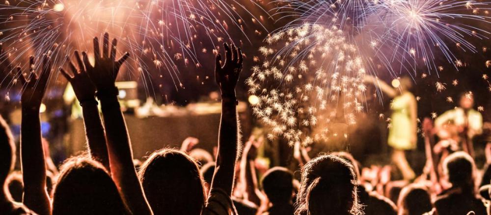 Uma imagem de várias pessoas observando uma queima de fogos de artifício