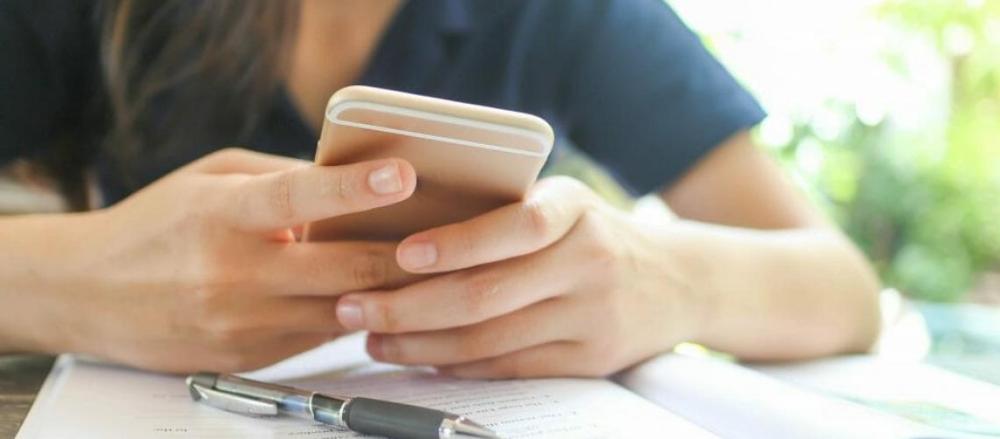 close de uma pessoa segurando o celular, indicando uma má postura