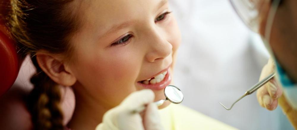 Criança sorrindo em um atendimento com dentista