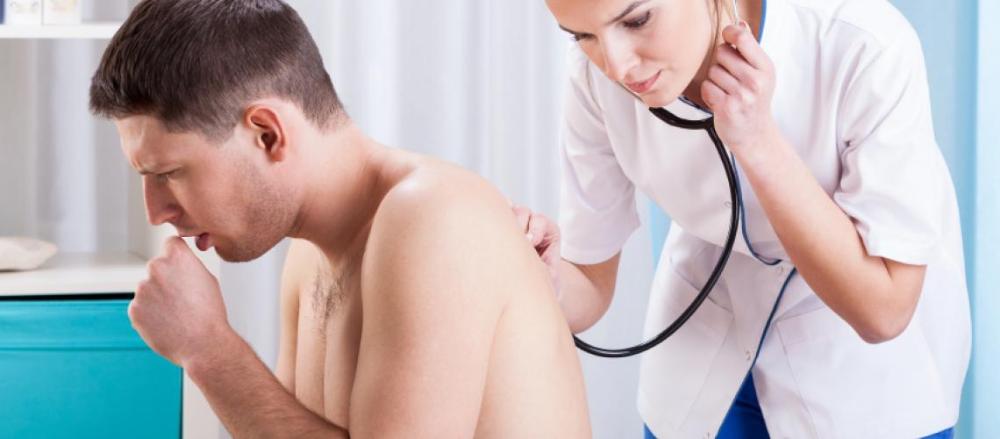 Homem tossindo, sendo examinado por médica
