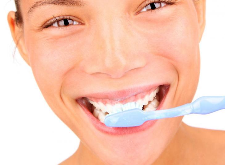 Imagem de uma jovem escovando os dentes, destacando a importância da saúde bucal, no combate às cáries