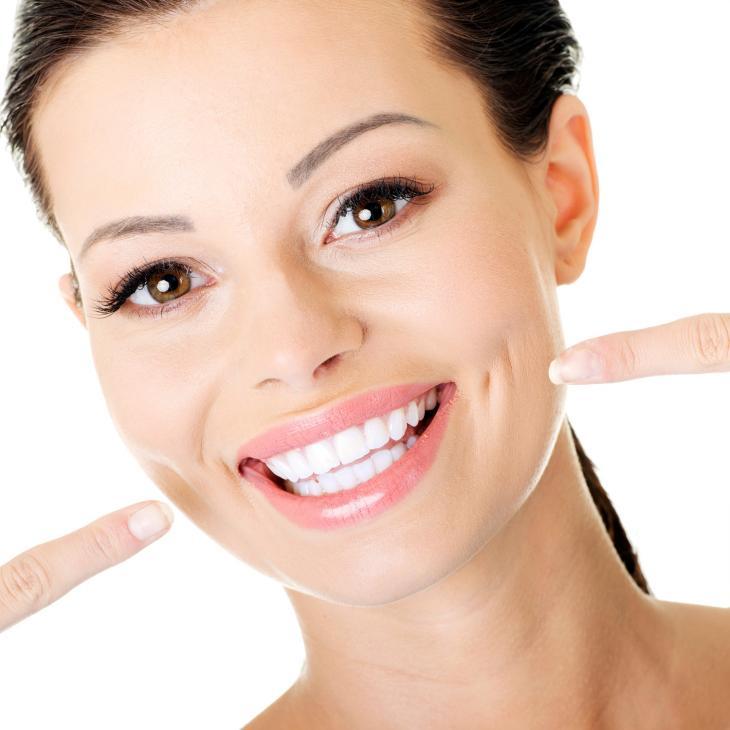 Imagem de uma mulher sorrindo e apontando para a própria boca com ambos os dedos indicadores