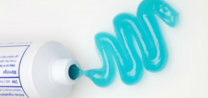 Imagem de um creme dental aplicado numa superfície, em formato de ondas, simbolizando a importância de escolher bem o creme dental
