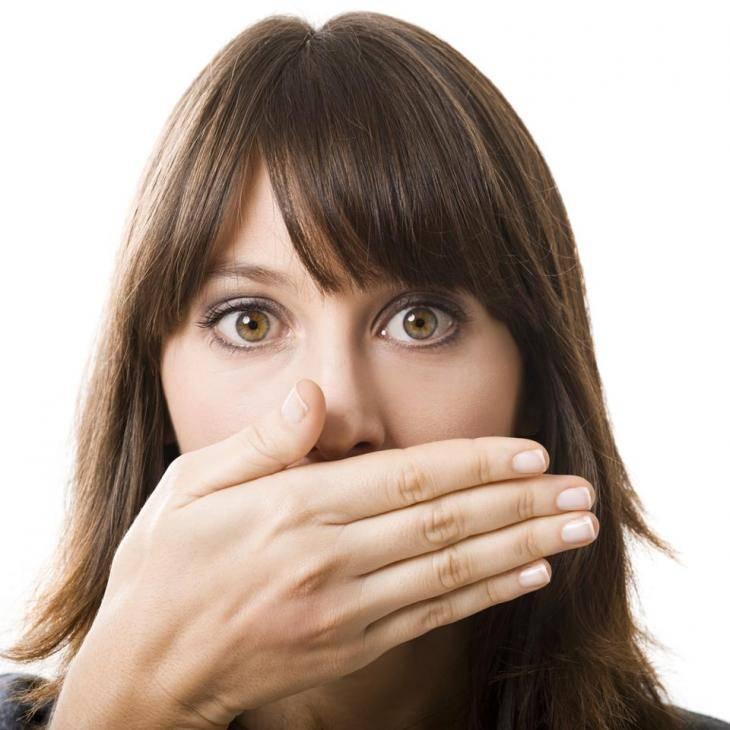 Imagem de uma mulher com os olhos arregalados e a mão cobrindo a boca