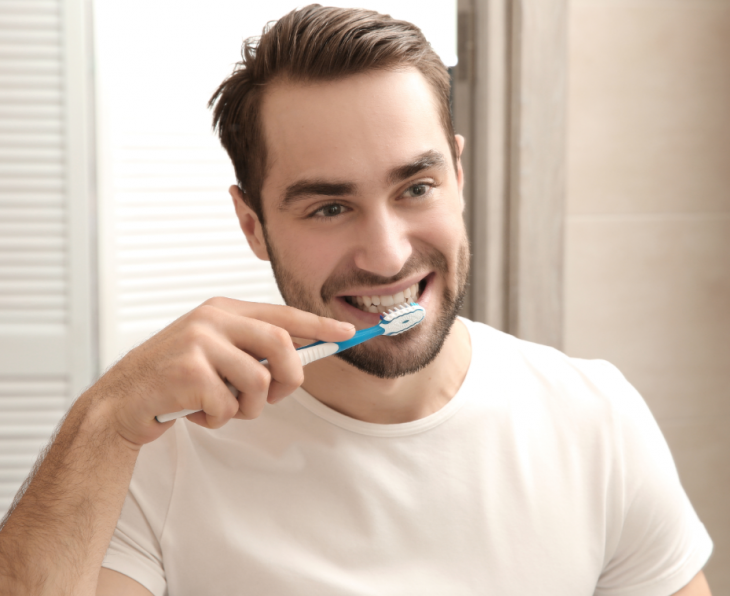 Imagem de um homem escovando os dentes, indicando a importância da higiene bucal na prevenção de cáries