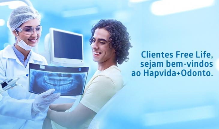 Imagem de um homem observando um raio-x de seus dentes enquanto passsa em uma consulta odontológica, com a frase Clientes Free Life, sejam bem-vindos ao Hapvida + Odonto