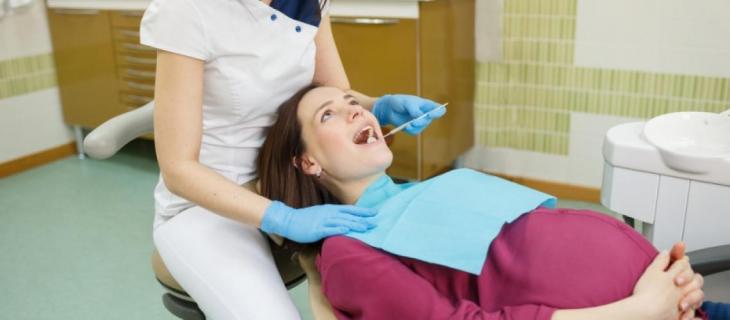 Imagem de uma mulher grávida em uma consulta com a dentista