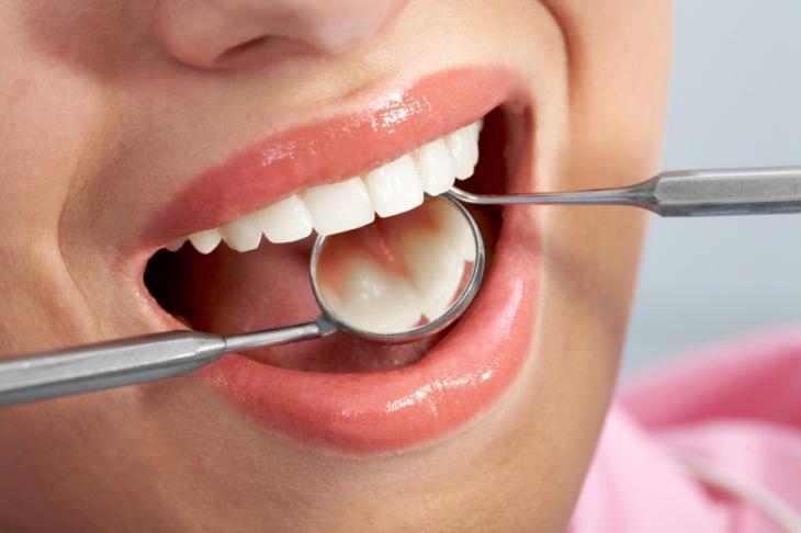 Imagem de uma mulher em uma consulta odontológica, simbolizando extração de dentes