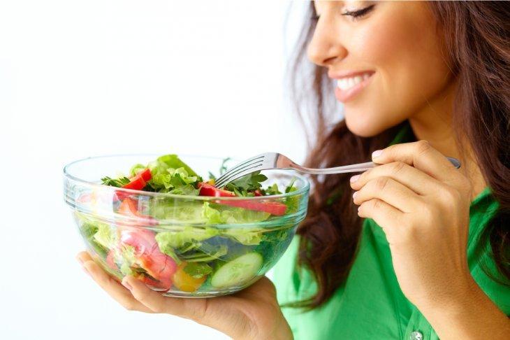 Imagem de uma mulher com um pote de salada nas mãos