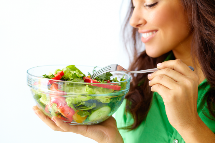 Imagem de uma mulher com um pote de salada nas mãos