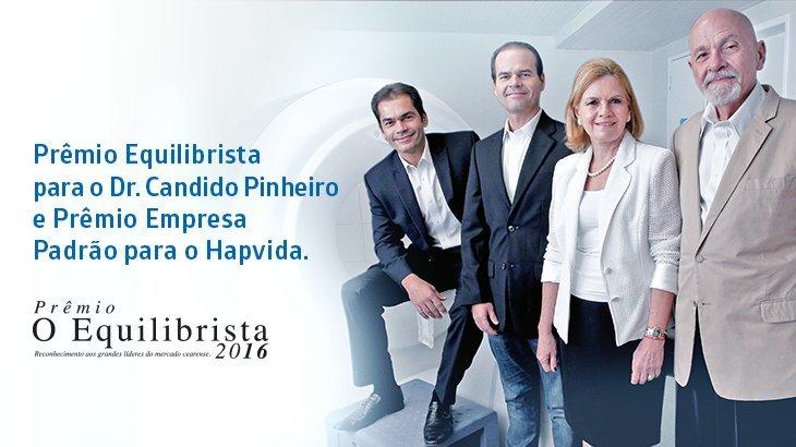 Imagem de 4 pessoas em pé e afrase Prêmio Equilibrista para o Dr. Candido Pinheiro e Prêmio Empresa Padrão para Hapvida