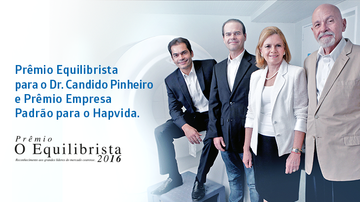 Imagem de 4 pessoas em pé e afrase Prêmio Equilibrista para o Dr. Candido Pinheiro e Prêmio Empresa Padrão para Hapvida